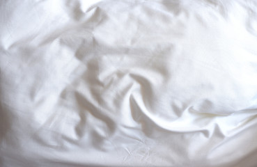 Obraz premium Soft white blanket. The sun's rays fall on the bed linen. Cosiness