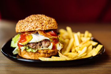 Tasty burger served with french fries 