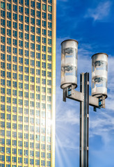 Strassenlaterne und moderne Hochhausfassade mit Sonnenreflex