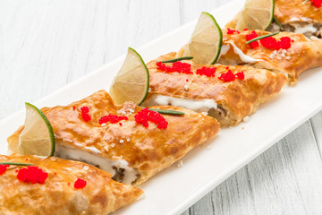 Puff-pizzas with mozzarella cheese, cherry tomatoes and baby basil.