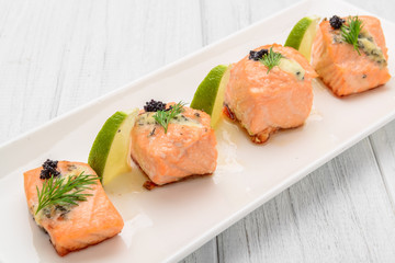 Grilled salmon, boiled potatoes and vegetables on a white plate