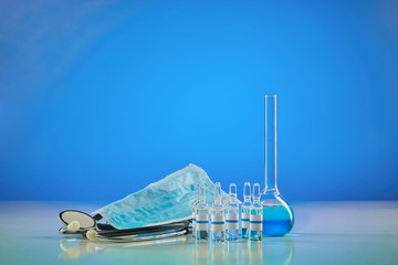 Medical flask with chemical reagent. Six ampoules with transparent liquid, mask and phonendoscope,...