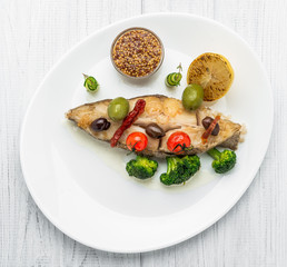 Fried halibut with vegetables and mustard, on the plate
