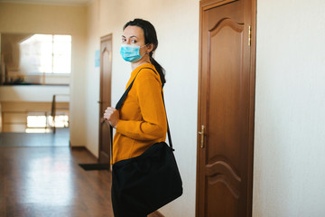 Woman with face mask going home. Global pandemic. Work from home during coronavirus quarantine.