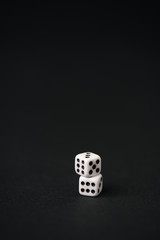 white and small dice on black with copy space