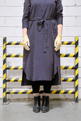 A young woman in a medical mask and gloves on the background of the restrictive barrier, concept....