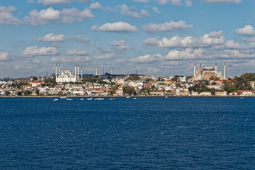 Fototapeta na wymiar The Suleymaniye Mosque and Hagia Sophia Museum dominate the crowded skyline of Istanbul on the shores of the Sea of Marmara.