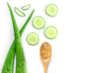 Green fresh cucumber, aloevera leaf,  and aloe gel in wooden spoon isolated on white background. Natural herbal medical plant, skincare, health and beauty spa concept. Top view. Flat lay.