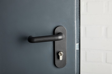 clean metal door with black handle after disinfection