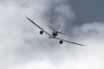 Airplane in the sky - cloudy day. Dramatic cloudy sky.
