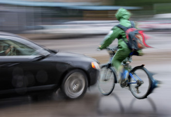Fototapeta na wymiar Dangerous city traffic situation with cyclist and car in the city