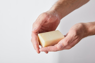 partial view of man using soap on grey background background