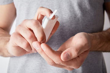 cropped view of adult man using hand sanitizer