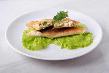 Pita triangles with cottage cheese, herbs, on a white plate
