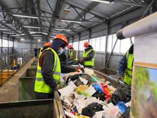 Fototapeta premium people in yellow vests sort out garbage