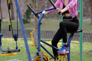young woman doing exercise in the park and listening music