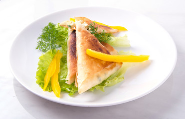 Pita triangles with cottage cheese, herbs, sweet pepper on a white plate