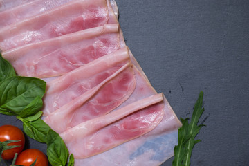 Tasty fresh red ham with basil leaves and cheery tomatoes