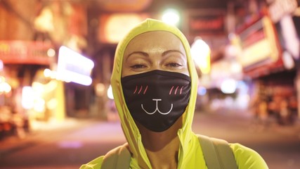 Woman close up look caucasian at Pattaya Walking Street with wearing protective medical mask....