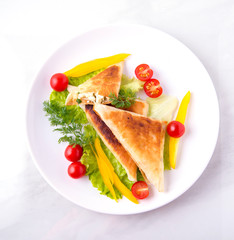 Pita triangles with cottage cheese, herbs, tomatoes on a white plate