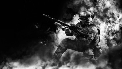 Portrait of a special forces soldier who reloads an assault rifle. The concept of military units....