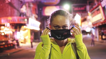 Woman close up look caucasian at Pattaya Walking Street with wearing protective medical mask. Lockdown quarantine isolation. Health virus protection coronavirus epidemic sars-cov-2 covid-19 2019-ncov.