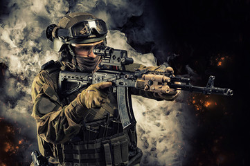 Portrait of a special forces soldier who is aiming at a collimator sight of a machine gun. The...