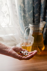 Woman holds pills in her hand - in the background herbal tee - vitamins -  dietary supplements - immune system boost