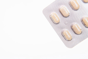 Pills  in a blister medical dressing. Yellow tablets in a blister on a white background close up with soft focus