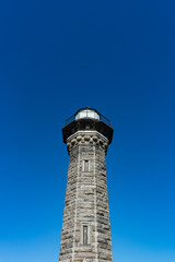The Historic Blackwell Island Lighthouse on Roosevelt Island in New York City with a Clear Blue Sky