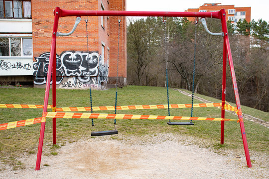 Park Kids And Children Playground For Game And Activity Empty And Closed For Coronavirus Or Covid19, Slide And Swing Empty Tape And Strips With Word STOP, Do Not Enter, Warning Sign Of Quarantine