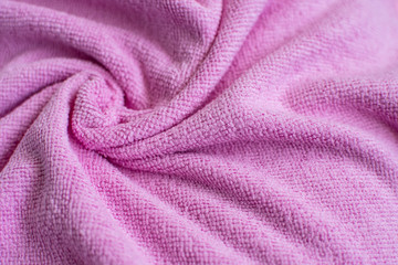Fototapeta na wymiar Wrinkled light pink microfiber cloth texture of microfiber towel closeup. pink microfiber cloth for cleaning objects and surfaces. Hygienic cleaning towel. fabric background.