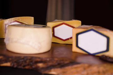 Quesos con etiquetas en blanco sobre madera