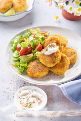 Healthy vegan food, Turmeric quinoa falafel with feta yogurt dip in a bright lunch setting. Selective focus. Middle Eastern platter. Delicious healthy lunch, snack. Diet, vegetarian concept.