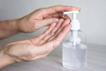 Man washing hands with sanitizer gel bottle or soap for coronavirus prevention, hygiene to stop spreading covid-19 (select focus)