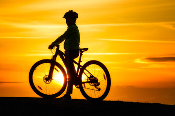 Fototapeta na wymiar Silhouette of young mountainbike cyclist at sunset, Sweden