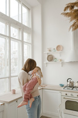 A young mother spends time with her little daughter at home.