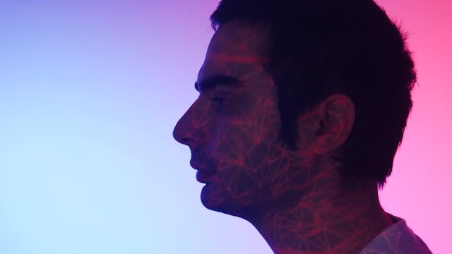 A dark haired Caucasian male getting his profile scanned using a biometric technology laser for self identification.