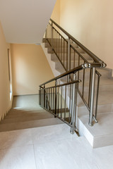 Modern stair case between floors. Stairs with metallic rail  in modern building