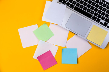 Home office desk workspace with laptop and paper sticker on yellow background. Flat lay, top view work business concept. Work at home concept on coronavirus quarantine