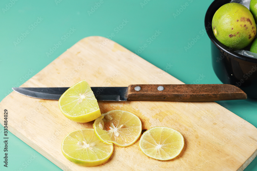 Poster lemon lime slice by kitchen knife on the wood butcher