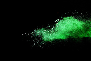 Green powder explosion on black background.