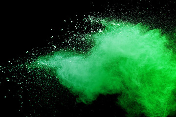 Green powder explosion on black background.