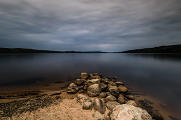 Fototapeta na wymiar Shore in front of lake with dark sky, Sweden.