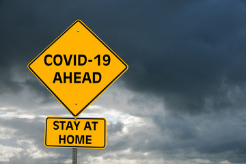Conceptual warning sign about coronavirus pandemic against stormy sky