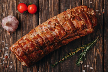 A piece of juicy smoked meat with spices on a wood background