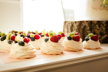 Frische Sahne Baiser mit Himbeeren Blaubeeren und Kiwi