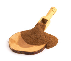 ground cinnamon spice powder in a wooden spoon on a white background