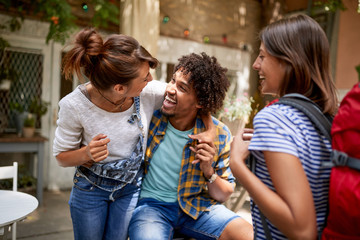 Guy with girls rejoices together in cafe