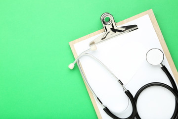 Text Doctor's Day with stethoscope and clipboard on green background